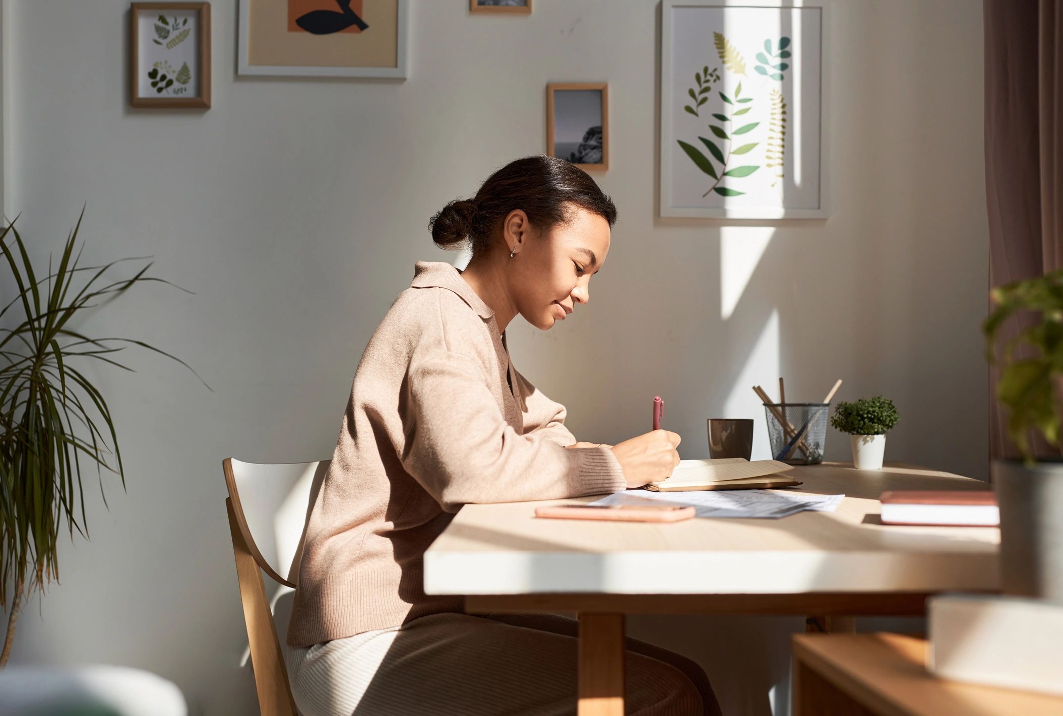 Person journaling and reflecting in a calm workspace